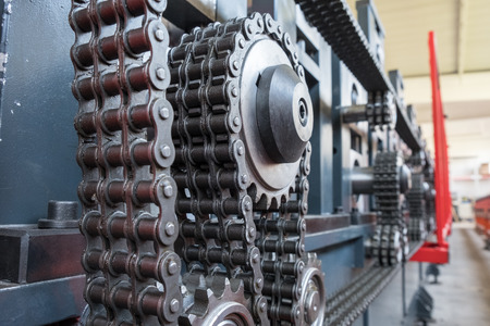 Triple strand roller chain going around three sprockets on industrial machineの写真素材