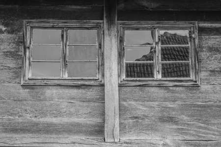 Two wooden windows on very old wooden buildings weathered in timeの写真素材