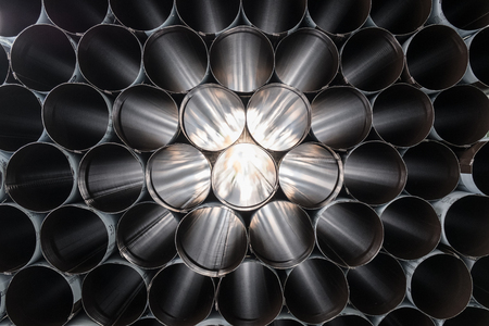 View through a stack of steel tubes with light reflecting in a star patternの写真素材