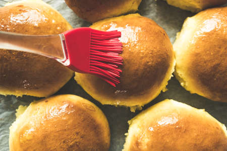 Freshly baked buns glazed with melted butterの写真素材