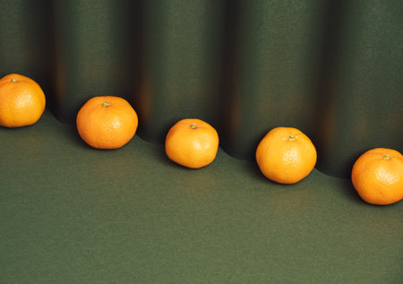 Fresh tripe tangerines arranged on a dark green background. Minimal still lifeの写真素材