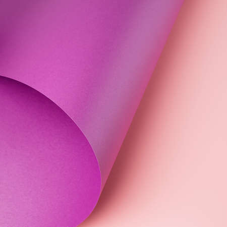 Metallic violet paper curved over light pink background. Minimal colorful backdropの写真素材