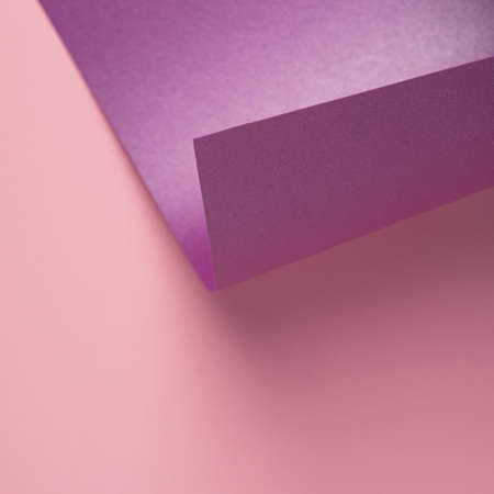 Metallic violet paper curved over light pink background. Minimal pastel backdropの写真素材