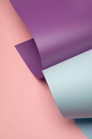 Pastel blue and violet rolled paper on a light pink background. Modern minimal backdropの写真素材