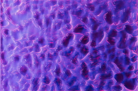 Abstract wavy surface with neon magenta and violet hues. Futuristic liquid background.の写真素材