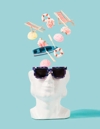 Summer items falling into the ceramic heat with sunglasses. Summertime, vacation planning minimal...
