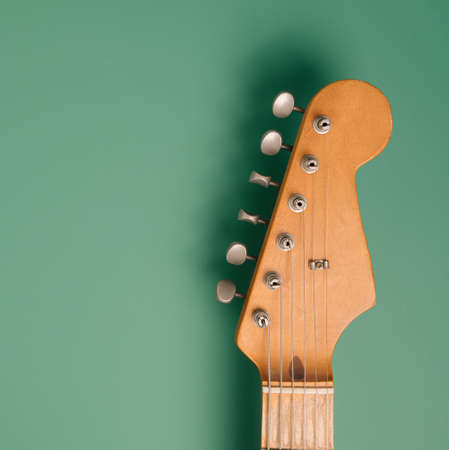 50s vintage electric guitar headstock on a pastel green background. Rock, blues minimal backdrop.の写真素材