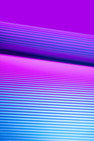 Violet and pink illuminated corrugated shapes. Geometric abstract background.