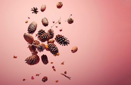 Pine cones falling against pastel red background. Winter season background. AI generated imageの素材