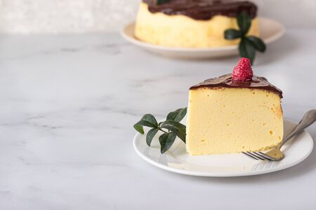 Jiggly and fluffy Japanese cotton souffle cheesecake decorated with chocolate glaze on ceramic...