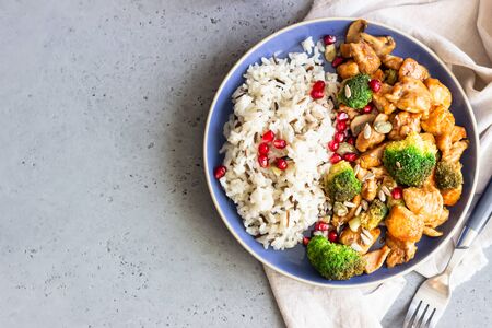 Curry chicken with rice, mushroom and broccoli decorated with pomegranate seeds. Healthy food. Asian cuisine.の写真素材