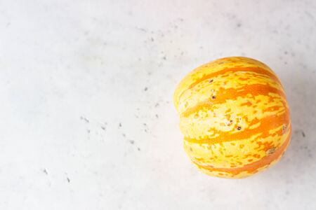 Trendy ugly organic small pumpkin on light gray stone background. Ugly food concept. Strange pumpkins.の写真素材