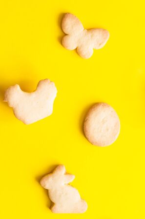 Easter cookies on yellow paper background. Easter symbols and traditions. Butter and sugar cookies.の写真素材