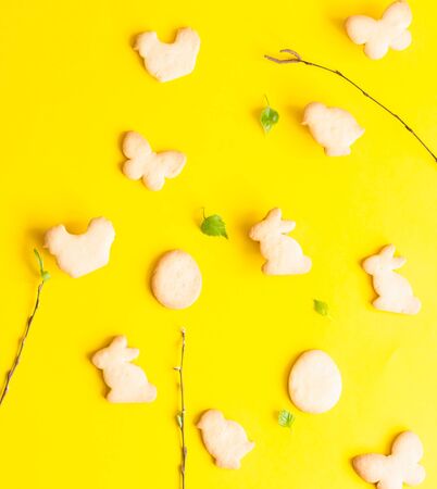 Easter cookies on yellow paper background. Easter symbols and traditions. Butter and sugar cookies.の写真素材