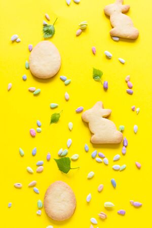 Easter cookies with multi-colored sprinkles on yellow paper background. Easter symbols and traditions. Butter and sugar cookies.の写真素材