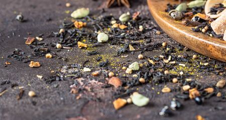 Mix of spices for hot spicy tea or Indian masala chai - cinnamon, anise, cardamom, nutmeg, pepper and brown sugar. Dark stone background.の写真素材