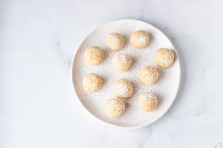 Traditional Indian festival sweets (Laddoo or Laddu) with coconut flakes on a ceramic plate, light...