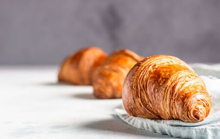 Fresh croissants on a gray linen napkin. Light gray concrete background.の写真素材