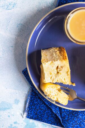 Plate with two pieces of pumpkin cheesecake and with caramel topping on a blue ceramic plate, light...