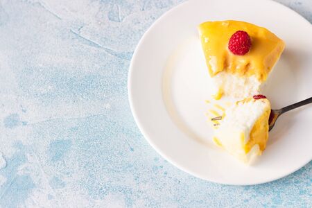 Slice of angel food cake with lemon curd and frozen berries (raspberry and blackberry), blue concrete background.の写真素材