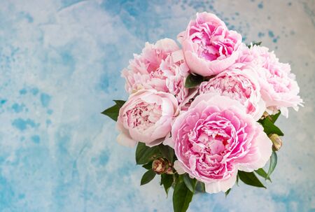 Bouquet of beautiful pink peonies, blue background. Top view. Flowers texture. Copy space.の写真素材