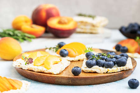 Mini rice cakes with blueberries, apricots, nectarines and cream cheese with honey for healthy...