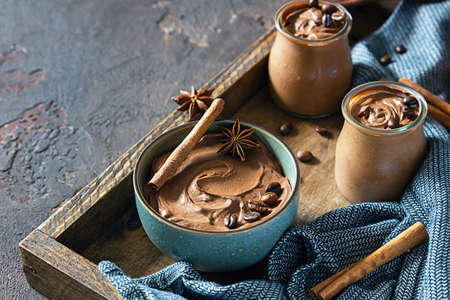 Chocolate dessert with coffee and spices in a wooden tray, selective focus. Rustic style. Spicy...