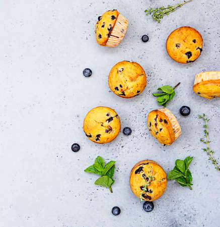 Fresh homemade delicious blueberry muffins decorated with thyme, fresh berries and mint on grey background.の写真素材