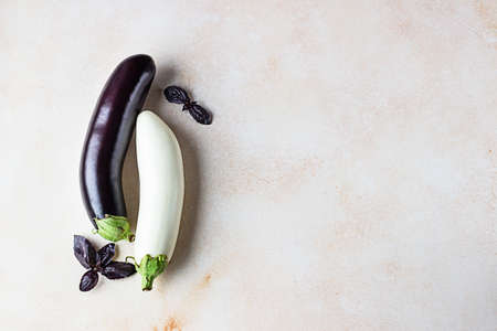 Fresh delicious white and purple eggplants with purple basil on concrete background. Top view.の写真素材
