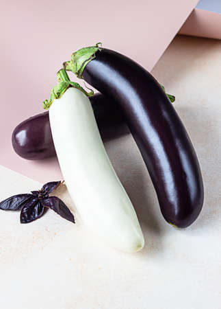 Fresh delicious white and purple eggplants with purple basil on concrete background. Top view.の写真素材