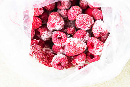 Frozen raspberries in transparent plastic bag. Close up. Concept of healthy eating. Close up.の写真素材