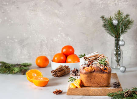 Winter bakery. Citrus loaf moist cake decorated with tangerines, rosemary, spices and sugar powder. Merry Christmas and Happy New Year concept.の写真素材