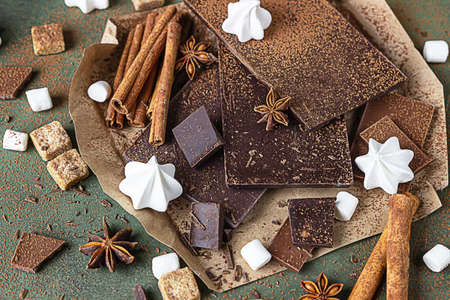 Dark and milk chocolate bar pieces, spices, brown sugar, meringue and marshmallow over concrete...