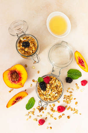 Homemade granola or muesli. Ingredients for healthy breakfast - granola, berries, peach, mint and honey. Top view.の写真素材
