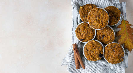 Healthy vegan homemade carrot or pumpkin muffins with raisin and nuts, light concrete background.の写真素材