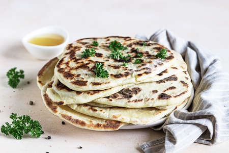 Indian homemade traditional flatbread with parsley and olive oil. Chapati, roti or naan Indian...