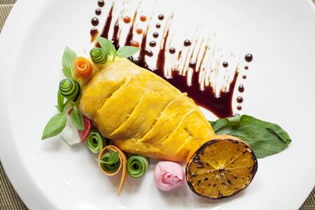 Cooked chicken breast designed by vegetables and sauceの写真素材