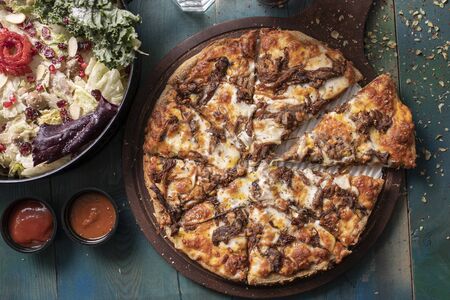 Delicious pizza with salad and friesの写真素材