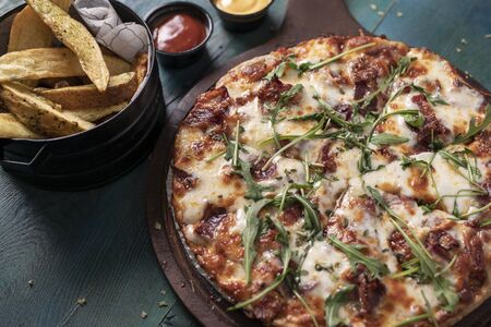 Delicious pizza with salad and friesの写真素材