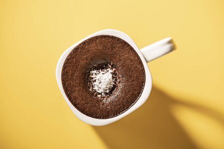 Hot chocolate drink in a mug. Top view of hot chocolate on yellow backgroundの写真素材