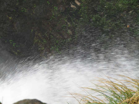 Water flowing down the rocks in the river. Close-up.