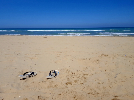 slippers on a sandy beachの写真素材