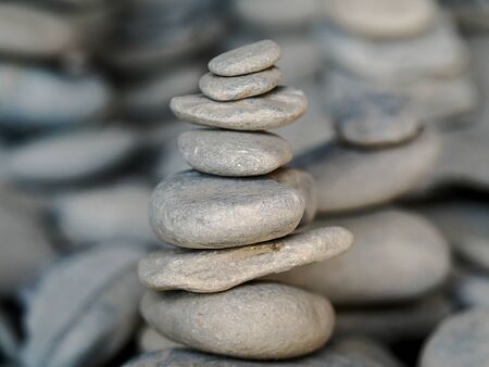 small zen stones on each other in perfect balance and harmony, with other stone sculptures in the...
