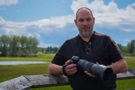 Portrait of a photographer with a camera on the background of natureの写真素材