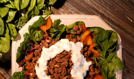 Vegetable salad with minced meat, carrots, spinach and sour creamの写真素材