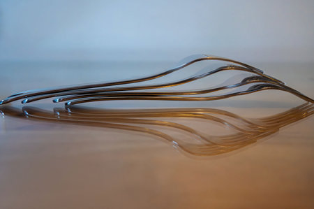 Close up of stacked stainless steel fork on blurred background reflecting on a glass surfaceの写真素材