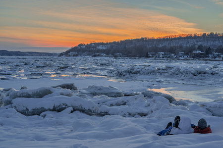 Couple admiring a sunset by the river, while sipping a hot coffeeの写真素材