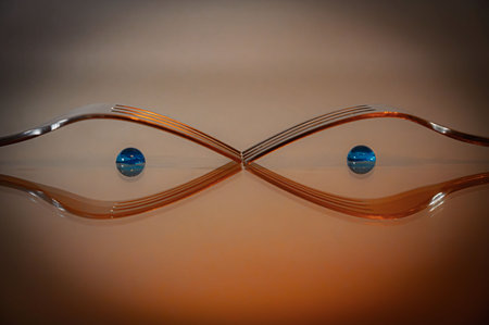 Close up of two forks reflecting on a glass surface looking like eyesの写真素材