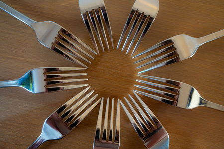 Circle made of cutlery on a wooden table. Top view.の写真素材