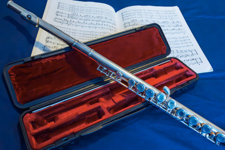 Flute and music sheet on blue background, closeup of photoの写真素材